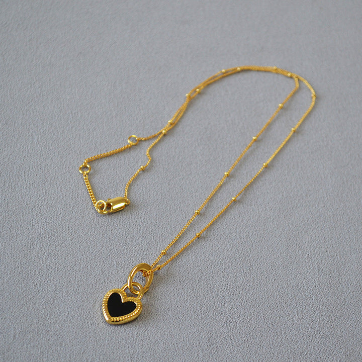 Collar con colgante en forma de corazón negro y blanco en oro