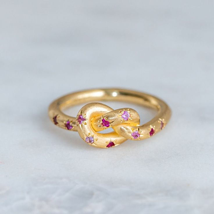 Anillo vintage rosa con nudo celestial dorado